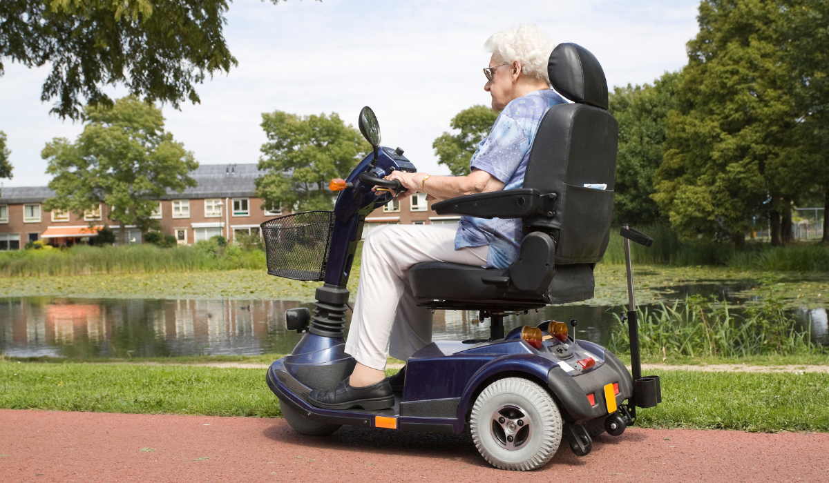 A rider on a mobility scooter outdoors