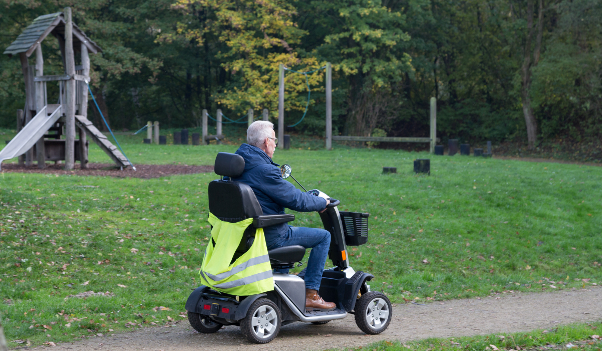 A mobility scooter rider outdoors on a sunny day