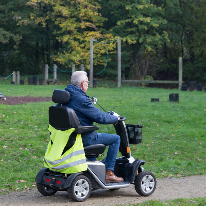 A mobility scooter rider outdoors on a sunny day